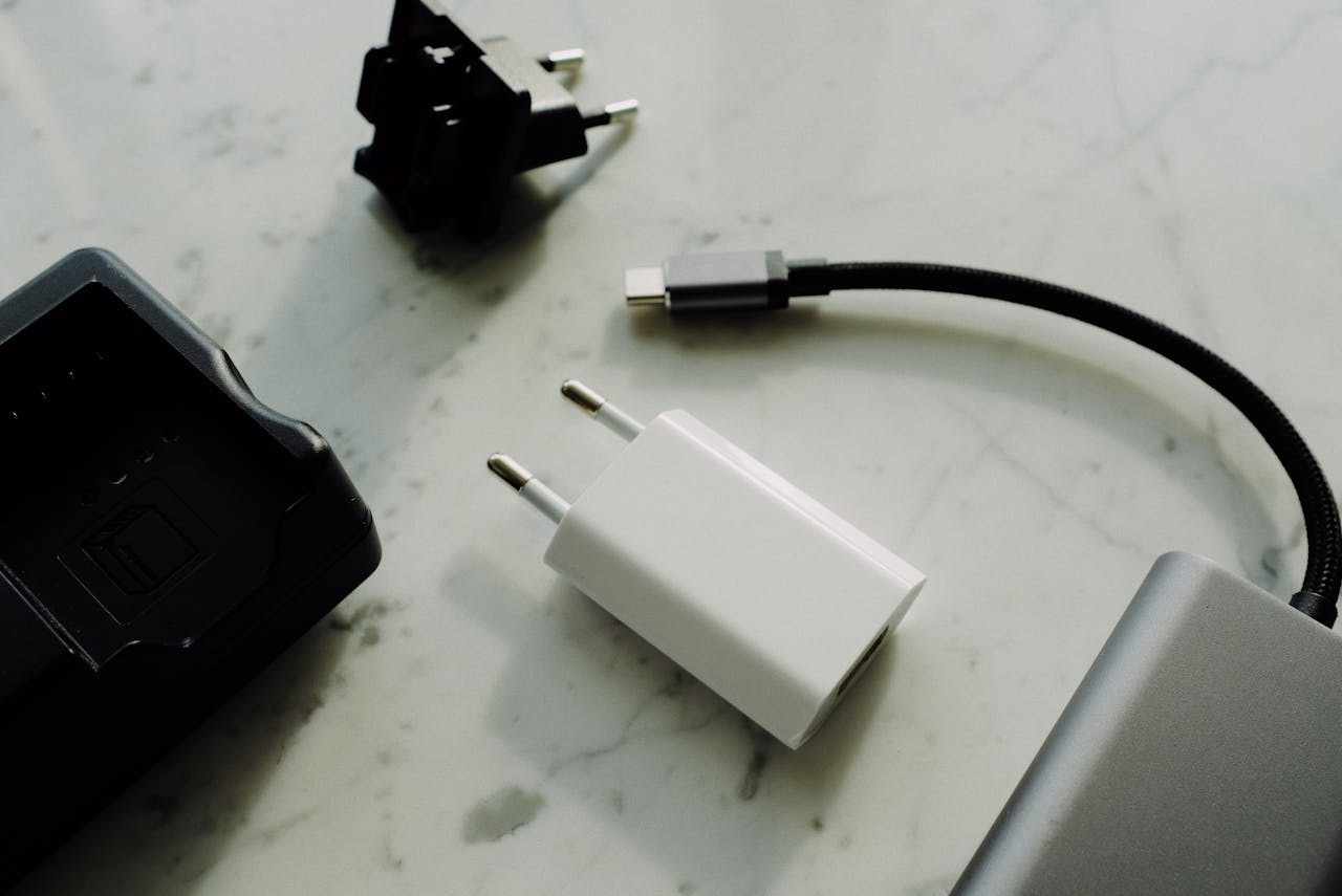 A flat lay of various electronic chargers and adapters on a marble surface.